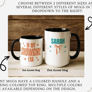 May include: Two white accent mugs with black handles and rims. One mug reads "IN MY SHOWGIRL ERA" in orange, the other says "SARAH" in teal. Both mugs have star and bow graphics. The mugs are 11oz and 15oz.