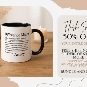 May include: White ceramic mug with a black handle and rim, featuring the definition of "Difference Maker" and the name "Ashley". A promotional graphic on the right advertises a flash sale with 50% off and free shipping.