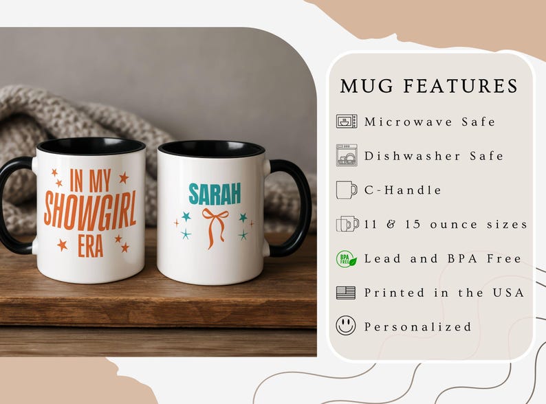 May include: Two white ceramic mugs with black handles and rims. One mug has the text "IN MY SHOWGIRL ERA" in orange, and the other says "SARAH" in teal with a bow graphic. Both mugs are on a wooden surface.