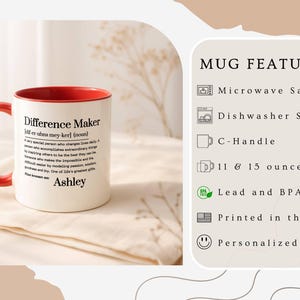 May include: White ceramic mug with a red interior and handle. The mug features the text "Difference Maker" with a definition and the name "Ashley". The mug is microwave and dishwasher safe, available in 11 and 15 ounce sizes, and printed in the USA.