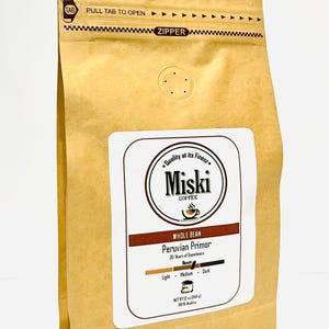 Może przedstawiać: Brązowa papierowa torba z zamkiem błyskawicznym. Torba ma białą etykietę z tekstem "Quality at its Finest" i "Miski Coffee" w k&oacute;łku. Etykieta zawiera r&oacute;wnież napis "Whole Bean Peruvian Primor 30 Years of Experience" i ma wskaźnik stopnia palenia z opcjami "Light", "Medium" i "Dark". Torba ma wagę netto 12 oz (340 g) i jest w 100% Arabica.