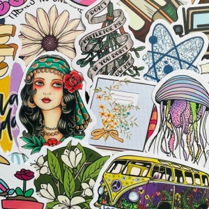Könnte beinhalten: Eine Auswahl an bunten Aufklebern mit verschiedenen Designs, darunter eine Blume, eine Frau mit Kopftuch, ein Mistelzweig, ein Notizbuch, eine Qualle, ein VW-Bus und eine Blume mit einer gelben Schleife. Die Aufkleber sind auf weißem Papier gedruckt und haben eine glänzende Oberfläche.