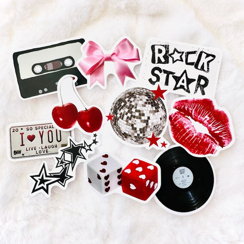 Puede incluir: Una colecci&oacute;n de pegatinas de vinilo que incluye una cinta de casete negra, un lazo rosa, el texto ROCK STAR, un par de cerezas rojas, una bola de discoteca plateada con estrellas rojas, labios rojos, una matr&iacute;cula con 20 SO SPECIAL I LOVE YOU, estrellas negras, dados y un disco.