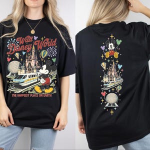 A black t-shirt with a Disney World-themed design, including Mickey Mouse, a castle, and various Disney-related elements.
