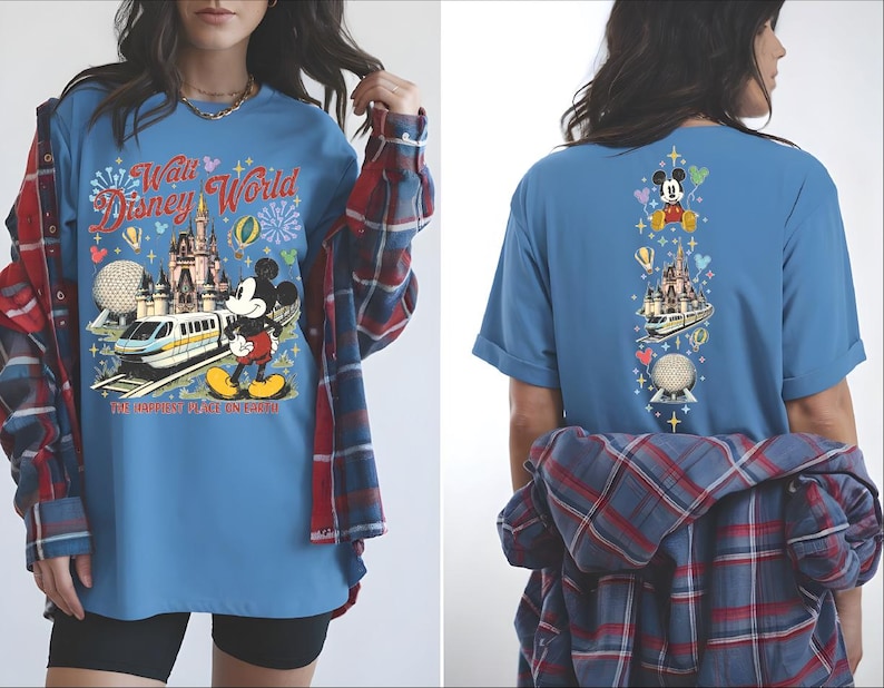 A woman wearing a blue t-shirt with a Disney World-themed design, including Mickey Mouse and various Disney landmarks.