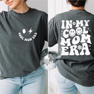a woman wearing a t - shirt that says in my cool mom era