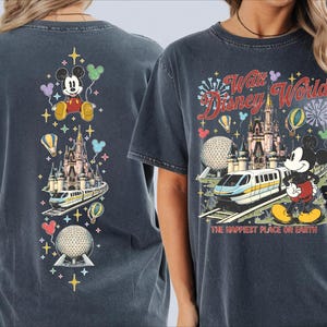 a woman wearing a gray t-shirt with a Disney World-themed design. The design includes Mickey Mouse, a castle, a train, and various Disney-themed elements.