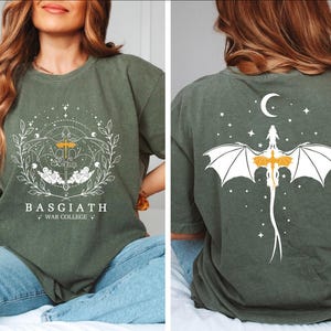 a woman sitting on a bed wearing a t - shirt with a bat on it