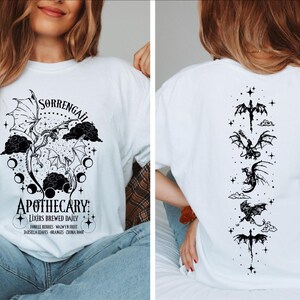 a woman wearing a white t - shirt with a graphic on it