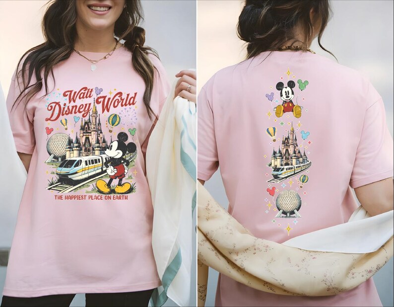 A woman wearing a pink t-shirt with a Disney World theme and various Disney characters and landmarks printed on it.
