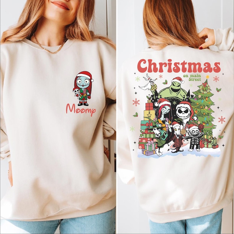 A woman wearing a white sweatshirt with a Christmas-themed design featuring characters from the movie "Sleeping Beauty".