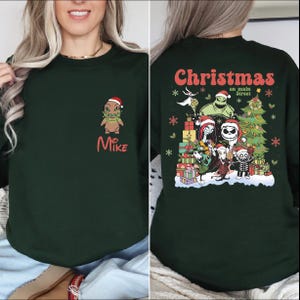 A woman wearing a green sweatshirt with a Christmas-themed design on the back.