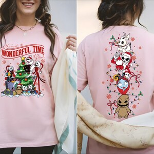 A woman wearing a pink t-shirt with a Christmas-themed design featuring characters from the movie " jack Skellington".