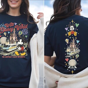 A woman wearing a navy blue t-shirt with a Disney World-themed design, including Mickey Mouse, the Eiffel Tower, and other iconic landmarks.