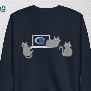 May include: Navy blue sweatshirt with a graphic of three grey cats and a laptop displaying the R programming language logo. The text "the coding cats" is in the upper left corner.
