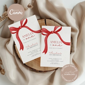 Puede incluir: Plantilla editable para una invitación de fiesta de primer cumpleaños. La invitación presenta un lazo rojo de acuarela y el texto "Amelia is one" en una fuente manuscrita. El texto "Please join us to celebrate Amelia's 1st Birthday" también está incluido.
