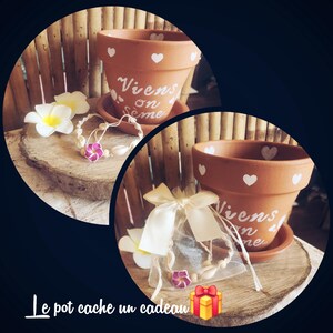 May include: Two terracotta flower pots with white heart designs and the words "Viens on sème" in white script. A bracelet with pink flowers and seashells is displayed with a gift bag and a white flower. The text "Le pot cache un cadeau" is at the bottom.