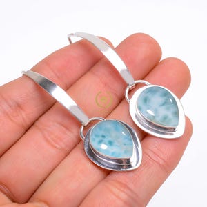 Peut inclure: Une paire de boucles d'oreilles pendantes en argent avec des pendentifs en forme de goutte de pierre précieuse bleue et blanche.