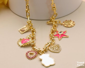 May include: A gold chain necklace with multiple charms, including a heart, a star, a bear, and a small book. The charms are pink and white enamel with gold accents.