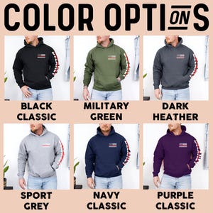 May include: Six different color options for a hooded sweatshirt with a small American flag on the front and a larger American flag on the sleeve. The colors are black, military green, dark heather, sport grey, navy, and purple.
