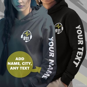 May include: Two hoodies, one gray and one black, featuring a white graphic of a headset and the number 911. The gray hoodie has "YOUR NAME" printed on the sleeve, and the black hoodie has "YOUR TEXT" printed on the sleeve. A yellow circle graphic says "ADD NAME, CITY, ANY TEXT".