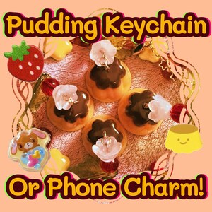 May include: Four miniature chocolate pudding charms with white flower accents and gold chains. The charms are arranged on a brown and pink patterned surface. The text "Pudding Keychain Or Phone Charm!" is displayed in the image.