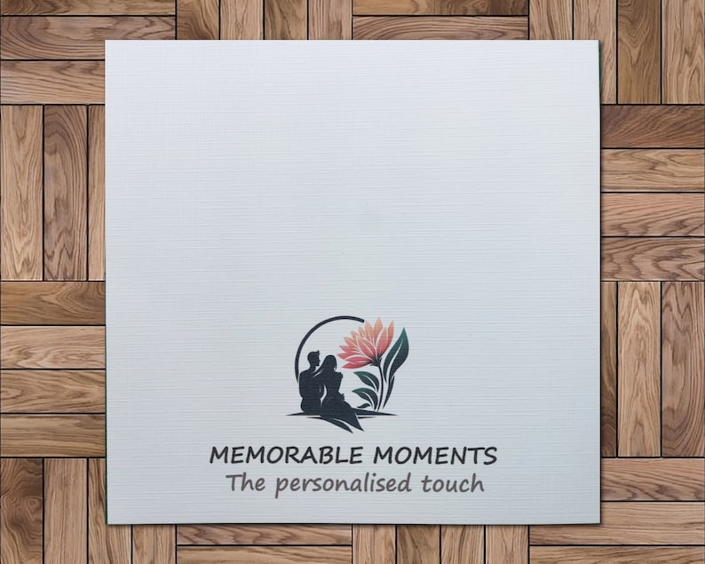 Op de afbeelding: Witte kaart met een logo met een silhouet van een stel dat met een bloem achter zich zit. De tekst "MEMORABLE MOMENTS The personalised touch" staat onder het logo.