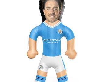 May include: An inflatable figure of a smiling man wearing a light blue soccer jersey with white shorts. The jersey has the text "ETIHAD AIRWAYS" and the Manchester City logo. The figure has a black hair outline.