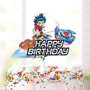 Puede incluir: Un pastel blanco con chispas de colores cubierto con un adorno de pastel que presenta un personaje de dibujos animados sosteniendo una peonza. El adorno de pastel dice "Feliz cumpleaños".