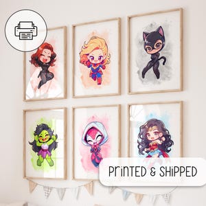 Può includere: Sei stampe incorniciate di personaggi di supereroi in stile acquerello. Ogni stampa presenta una diversa supereroina femminile, tra cui Black Widow, Captain Marvel, Catwoman, She-Hulk, Spider-Gwen e Wonder Woman. Le stampe sono esposte su una parete bianca con uno stendardo di bandiere appeso sotto. Il testo "PRINTED & SHIPPED" è visualizzato nell'angolo inferiore destro dell'immagine.