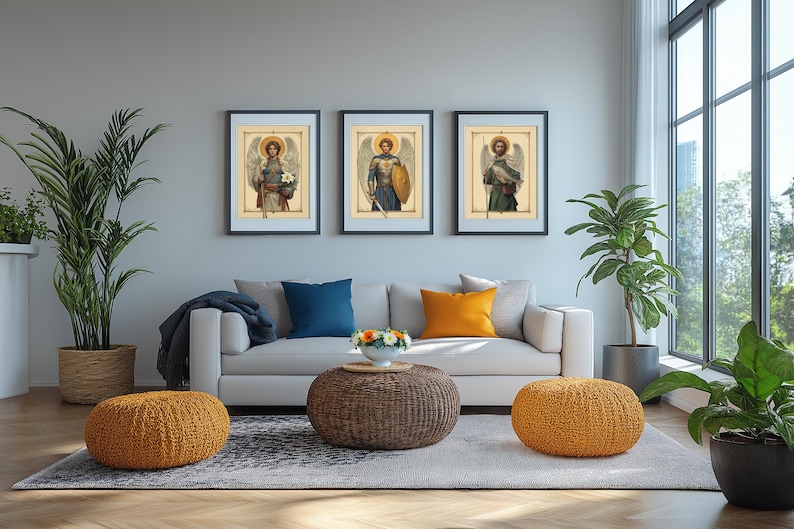 May include: Three framed prints of angels with wings, each with a different pose and background. The prints are hung on a light grey wall above a white sofa with blue and orange throw cushions.