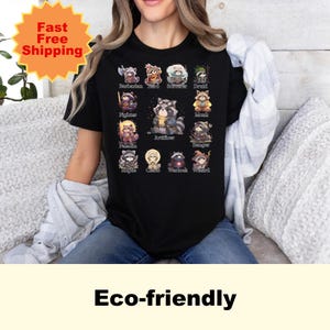 May include: Black t-shirt featuring a grid of raccoon illustrations, each depicting a different fantasy class such as "Barbarian" and "Wizard." The shirt also has the text "Eco-friendly" at the bottom.