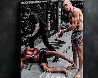May include: A canvas print depicting a UFC fight scene. The image shows a referee and two fighters in the octagon. One fighter is standing, while the other is on the ground. The word "Chama" is written in cursive at the bottom.