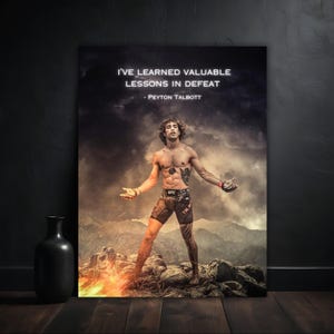 Puede incluir: Un póster motivacional con la cita "HE APRENDIDO VALIOSAS LECCIONES EN LA DERROTA - PEYTON TALBOTT." La imagen muestra a un luchador de pie sobre una superficie rocosa con un fondo ardiente. El póster se muestra en una pared oscura.