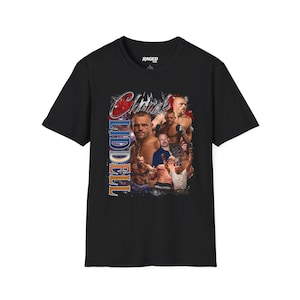 Puede incluir: Camiseta negra con un diseño gráfico de estilo vintage de Chuck Liddell. El diseño incluye múltiples imágenes de Liddell, el nombre "Chuck" en rojo y el nombre "Liddell" en azul y naranja. La camiseta tiene cuello redondo y mangas cortas.