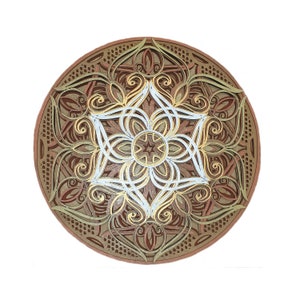 Puede incluir: Un mandala redondo de madera con intrincados recortes y un diseño en capas. El mandala está pintado en tonos marrones, dorados y blancos.