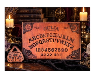 May include: A rectangular wooden Ouija board with a dark stained finish featuring the alphabet, numbers zero through nine, the words YES, NO, and GOOD BYE, and a sun and moon design. A matching wooden planchette with an eye graphic is included.