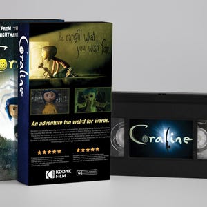 K&ouml;nnte beinhalten: Eine Coraline VHS-Kassette und die dazugeh&ouml;rige Papph&uuml;lle. Die H&uuml;lle zeigt den Filmtitel, den Text Be careful what you wish for und An adventure too weird for words. Die schwarze Kassette hat ein Coraline-Etikett mit blauem Lichteffekt-Hintergrund.