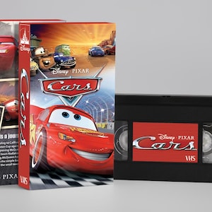 Può includere: Un set di VHS e scatola per il film Disney Pixar "Cars". La copertina presenta Saetta McQueen e altri personaggi. La videocassetta VHS è nera con un'etichetta rossa con la scritta "Cars".
