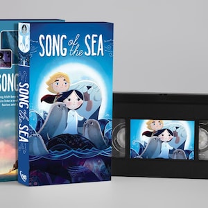 Può includere: Una videocassetta VHS di Song of the Sea con la sua custodia in cartone blu. La copertina raffigura un ragazzo e una ragazza circondati da foche su uno sfondo al chiaro di luna. Il titolo Song of the Sea e il logo VHS ufficiale sono sul dorso.