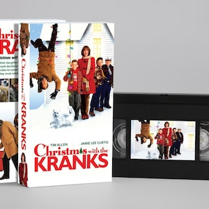 Op de afbeelding: Een VHS-cassette en de bijbehorende kartonnen hoes voor de film Christmas with the Kranks. De hoes toont een man die ondersteboven hangt, een vrouw, kinderen en een witte kat in de sneeuw. De titel staat in rode en zwarte letters op een witte achtergrond.