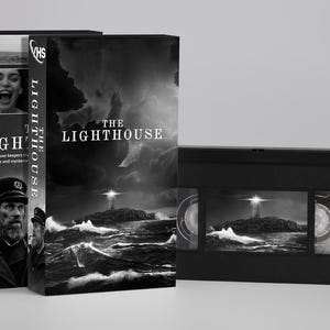 Peut inclure: Une cassette VHS en noir et blanc avec son étui en carton assorti pour le film The Lighthouse. L'emballage présente un phare sur une île rocheuse au milieu d'une mer agitée, le portrait d'un gardien barbu et le titre The Lighthouse.