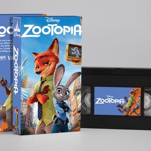Puede incluir: Dos cajas de cintas VHS azules y una cinta VHS negra de la película de animación de Disney "Zootrópolis". Las cajas presentan el título y los personajes de la película, incluyendo un zorro y un conejo. La cinta VHS también muestra el título y los personajes de la película.