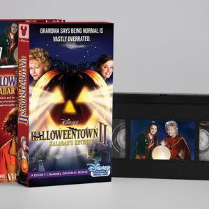 Op de afbeelding: Een Halloweentown II: Kalabar's Revenge VHS-band met kartonnen hoes. De cover toont een gloeiende pompoen, de tekst 'Grandma says being normal is vastly overrated' en afbeeldingen van de cast. De zwarte VHS-band is ook zichtbaar.