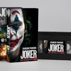Peut inclure: Un ensemble de cassettes VHS et d'étuis pour le film "Joker" avec Joaquin Phoenix. L'étui présente le titre du film et un gros plan du visage du Joker. La cassette VHS affiche également le titre du film.