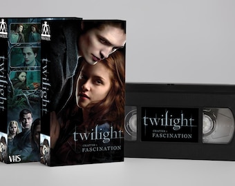 May include: A VHS tape and two boxes for the movie "Twilight: Chapter 1 - Fascination." The boxes feature images of the actors and the movie title. The VHS tape is black with the movie title on the label.