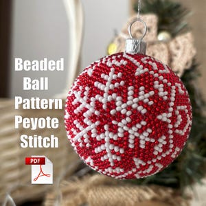 May include: A red and white beaded Christmas bauble with a snowflake pattern. The bauble is made using peyote stitch and is available as a PDF pattern.