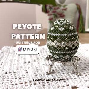 以下が含まれることがあります： 緑、白、金色の模様のビーズの卵が、装飾的な銀色のスタンドに飾られています。「PEYOTE PATTERN」の文字が「SUITABLE FOR MIYUKI」の上にあります。 Etsyショップ名「SYLIANKY.ETSY.COM」が一番下にあります。