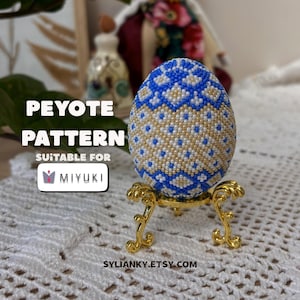 Könnte beinhalten: Ein mit Perlen besetztes Ei mit blauem und goldenem Muster, präsentiert auf einem goldfarbenen Ständer. Das Ei ist mit kleinen Perlen in einem geometrischen Design verziert. Der Text auf dem Bild lautet "PEYOTE PATTERN" und "SUITABLE FOR MIYUKI". Der Etsy-Shop-Name "SYLIANKY.ETSY.COM" ist ebenfalls sichtbar.