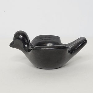 May include: A black ceramic bird-shaped dish. The dish is smooth and has a glossy finish.